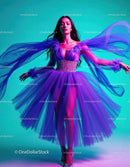 Elegant Woman in Flowing Purple Tulle Dress Against Colorful Background