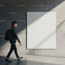Blurred man walking past large blank canvas on concrete wall