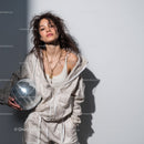 Stylish Woman in Metallic Outfit Holding Disco Ball for Modern Fashion