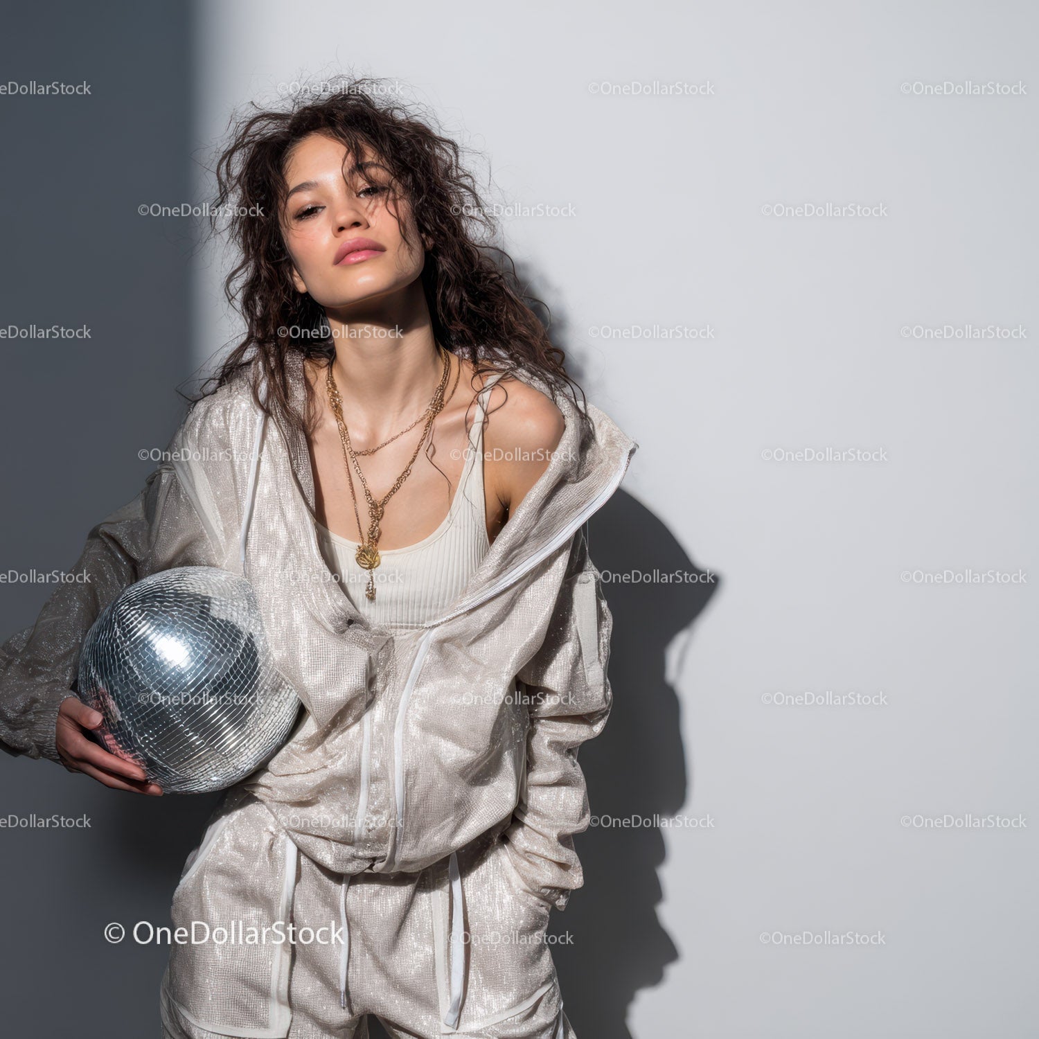 Stylish Woman in Metallic Outfit Holding Disco Ball for Modern Fashion