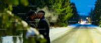 Couple sharing a tender kiss on a snowy evening