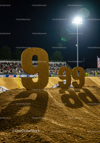 Large numbers displayed on dirt track during night event