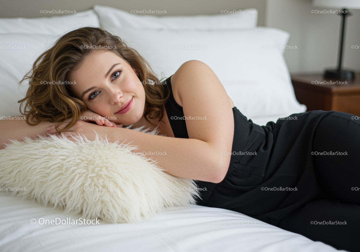 Young woman relaxing on bed with cozy pillow
