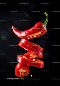 Floating Slices of Fresh Red Chili Pepper on Black