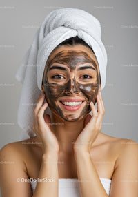Young Woman Applying Facial Mask for Skin Care Treatment