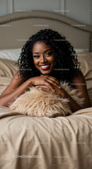 Smiling woman relaxing on bed with cozy pillow