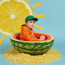 Boy sitting inside a watermelon bowl with sun decor