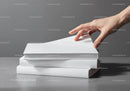Hand Reaching for a Book from a Stack on Gray Surface