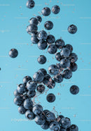 Fresh blueberries splashing in clear blue water
