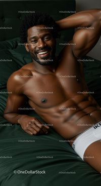 Smiling man relaxing on dark green bed in white underwear