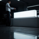 Man Holding Key Near Illuminated Modern Desk in Dark Room
