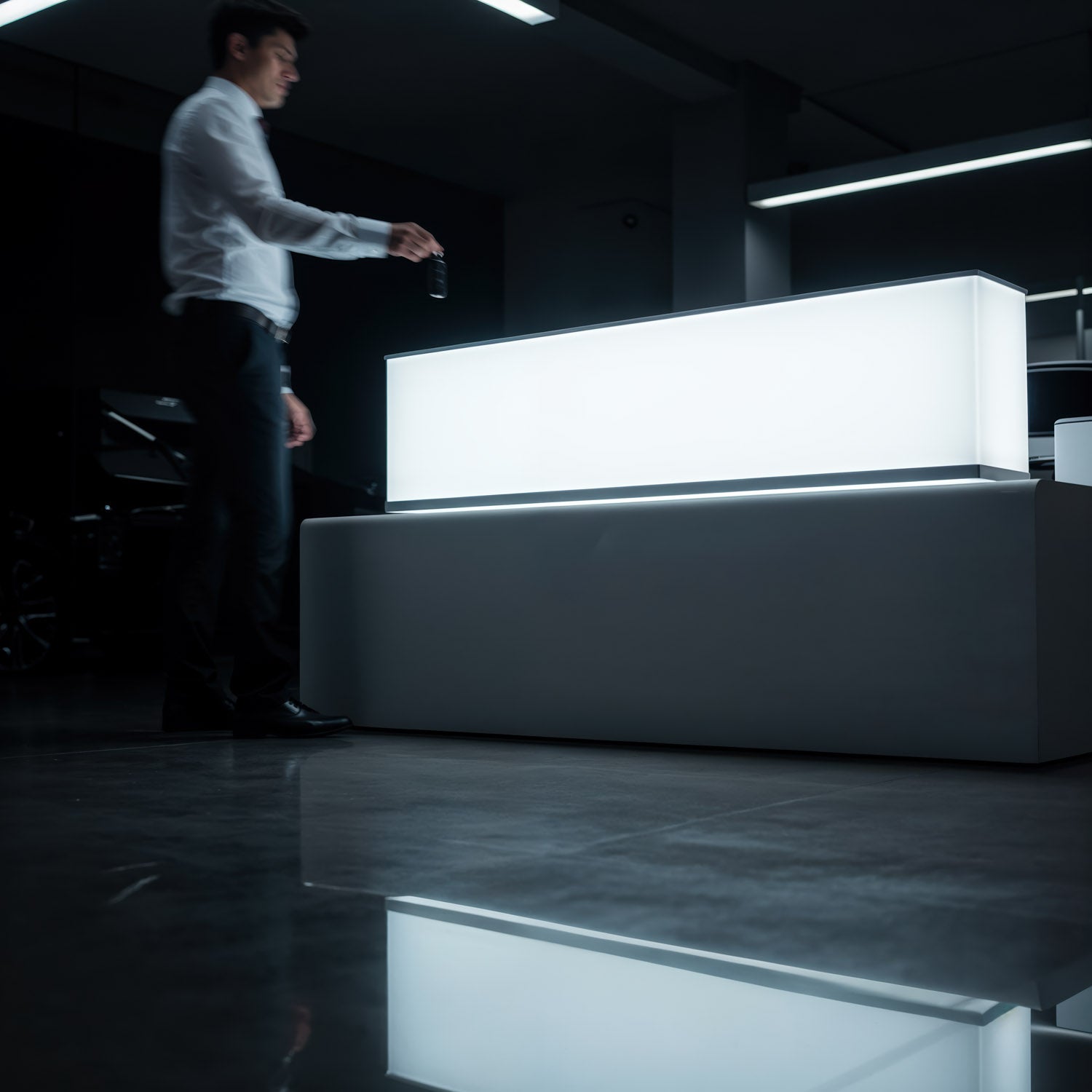 Man Holding Key Near Illuminated Modern Desk in Dark Room