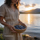 Woman holding fresh blueberries basket by the lake