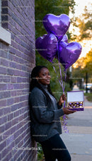 Woman Holding Purple Heart Balloons and Gift Box Outdoors