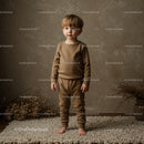 Toddler boy standing barefoot on soft rug indoors
