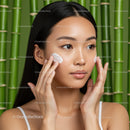Young Woman Applying Facial Moisturizer in Natural Setting