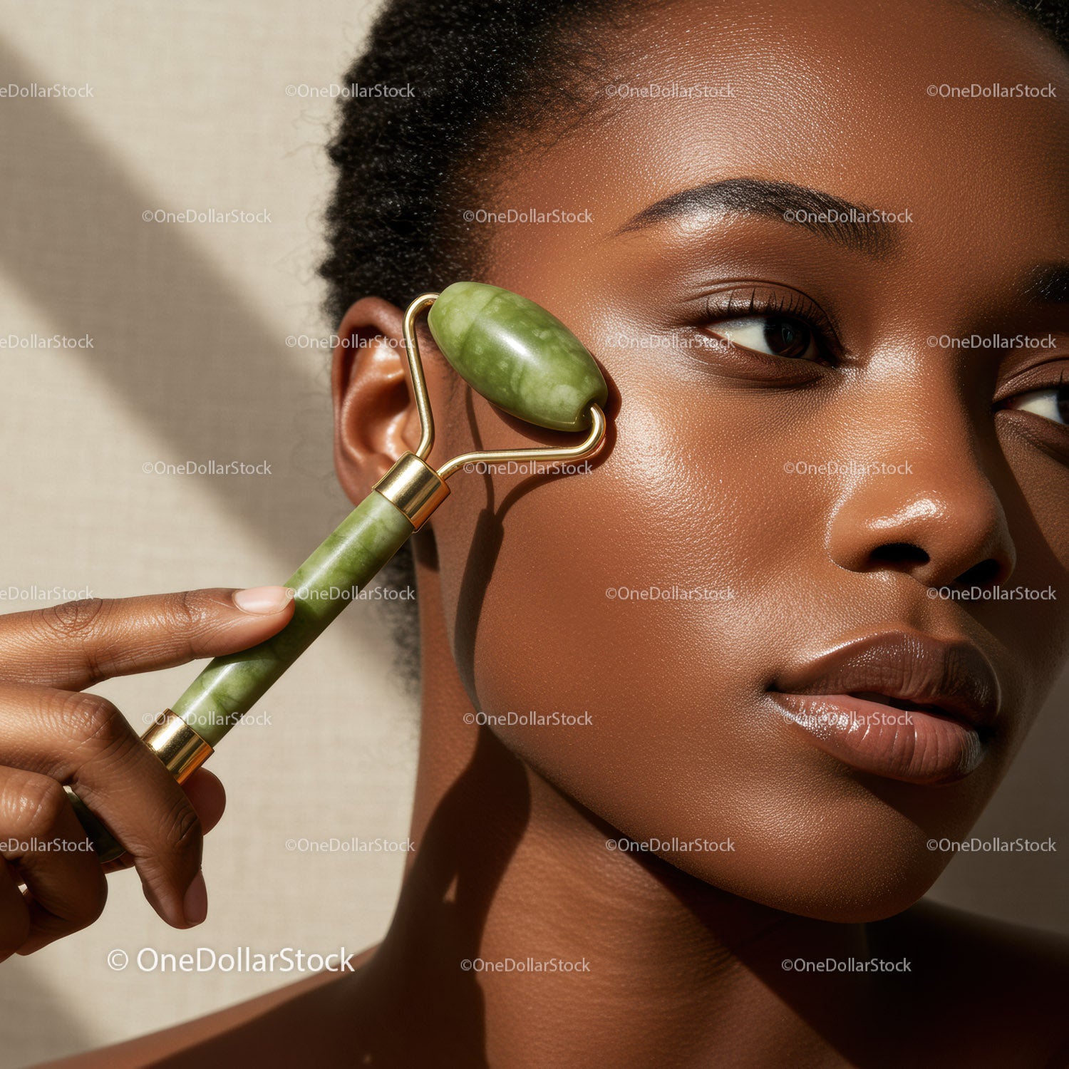 Portrait of Woman Using Jade Roller for Face Massage with Glowing Skin