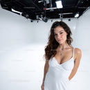 Young Woman in White Dress with Jewelry Posing in Studio
