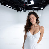 Young Woman in White Dress with Jewelry Posing in Studio
