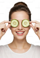 Smiling Woman Holding Cucumber Slices Over Eyes for Fresh Skincare