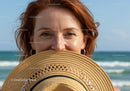 Smiling Woman with Straw Hat at the Beach Enjoying Summer Vacation
