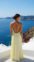 Stylish woman in yellow dress overlooking sea cliffs