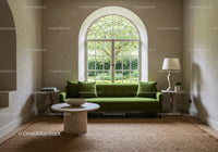 Minimalist living room with green sofa and arched window