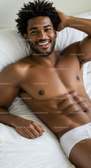 Smiling man relaxing comfortably on white bed