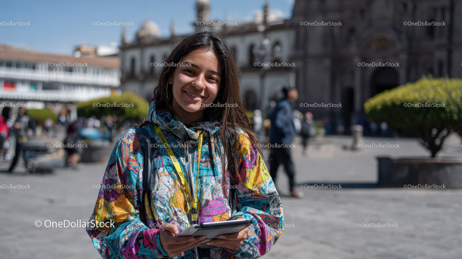 Young Woman Smiling in Colorful Jacket in City Square