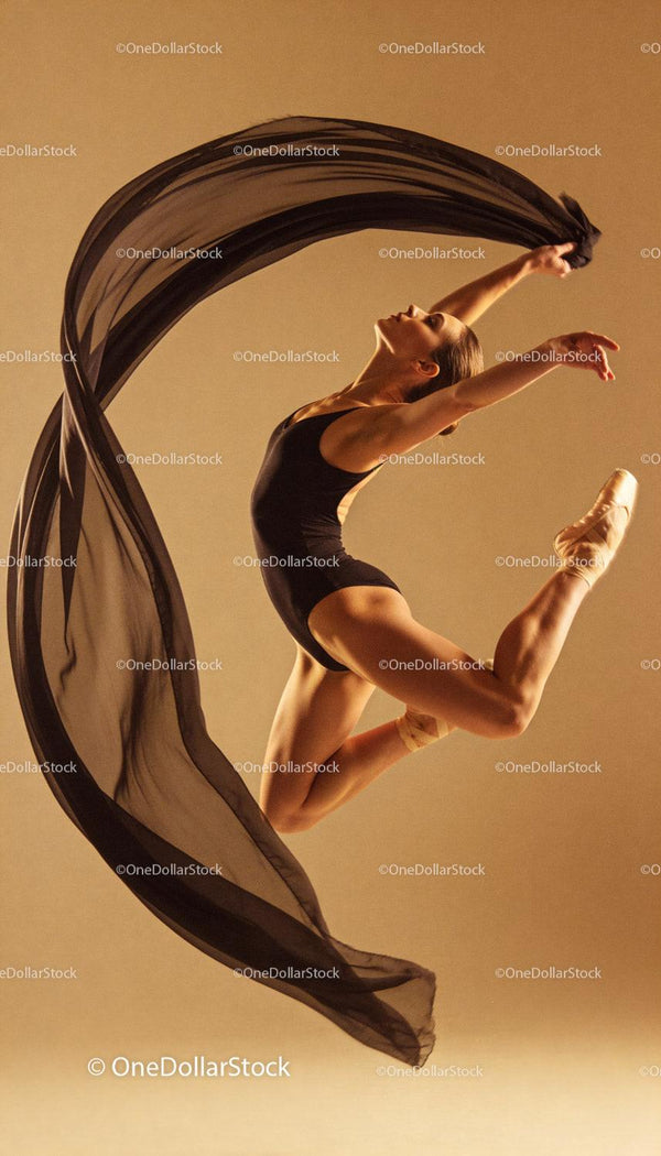 Graceful ballet dancer leaping with flowing scarf