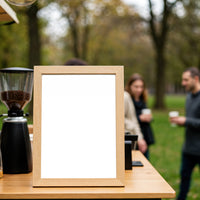 Blank wooden frame on table at outdoor coffee stand