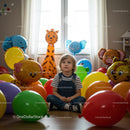 Thoughtful child surrounded by colorful balloons indoors