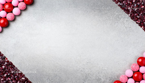 Colorful Candy and Crushed Red Stones On Gray Background