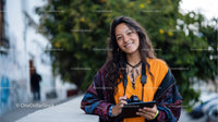 Young Woman Smiling with Camera Outdoors in Natural Setting
