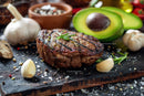 Juicy Grilled Steak with Fresh Avocado and Garlic on Rustic Board