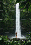 Tropical Jungle Waterfall Scene Featuring a Woman on a Rock