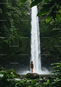 Tropical Jungle Waterfall Scene Featuring a Woman on a Rock