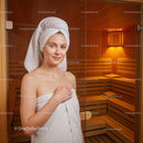 Young Woman Relaxing in Sauna with Wooden Interior and Towel