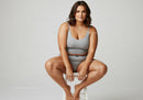 Confident Woman in Gray Casual Outfit Sitting on Stool in Studio