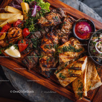Variety of Grilled Kebabs and Accompaniments on Rustic Serving Tray