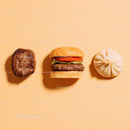 Gourmet Burger with Lettuce and Tomato Next to Grilled Steak and Dumpling