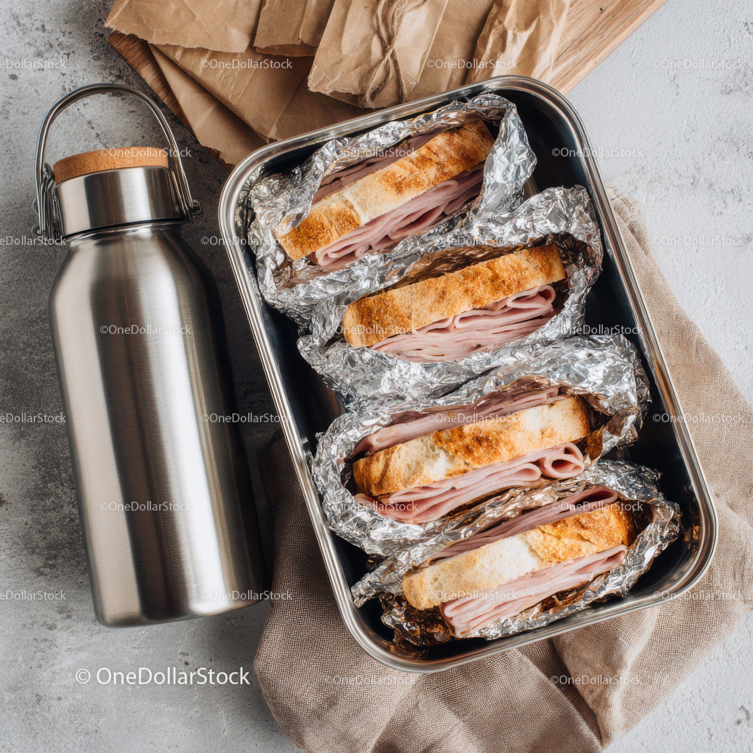 Ham Sandwiches in Foil with Thermos on a Wooden Board for Lunch