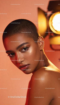 Confident woman with shaved head and glowing makeup