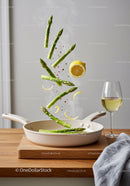 Fresh asparagus and lemon slices sautéed in pan