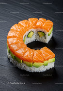 Fresh salmon and avocado sushi roll on black slate