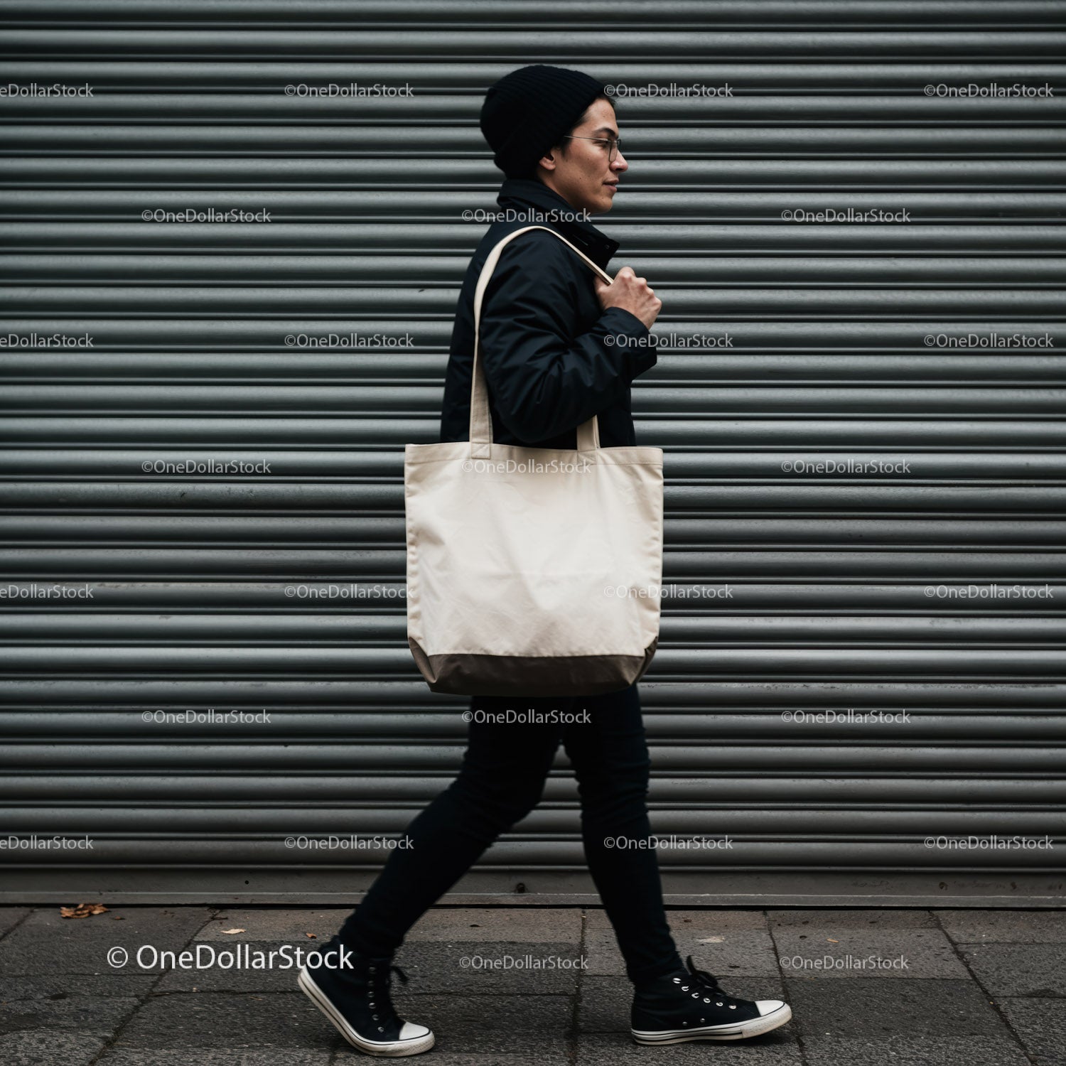 Casual man walking with canvas tote bag in urban setting