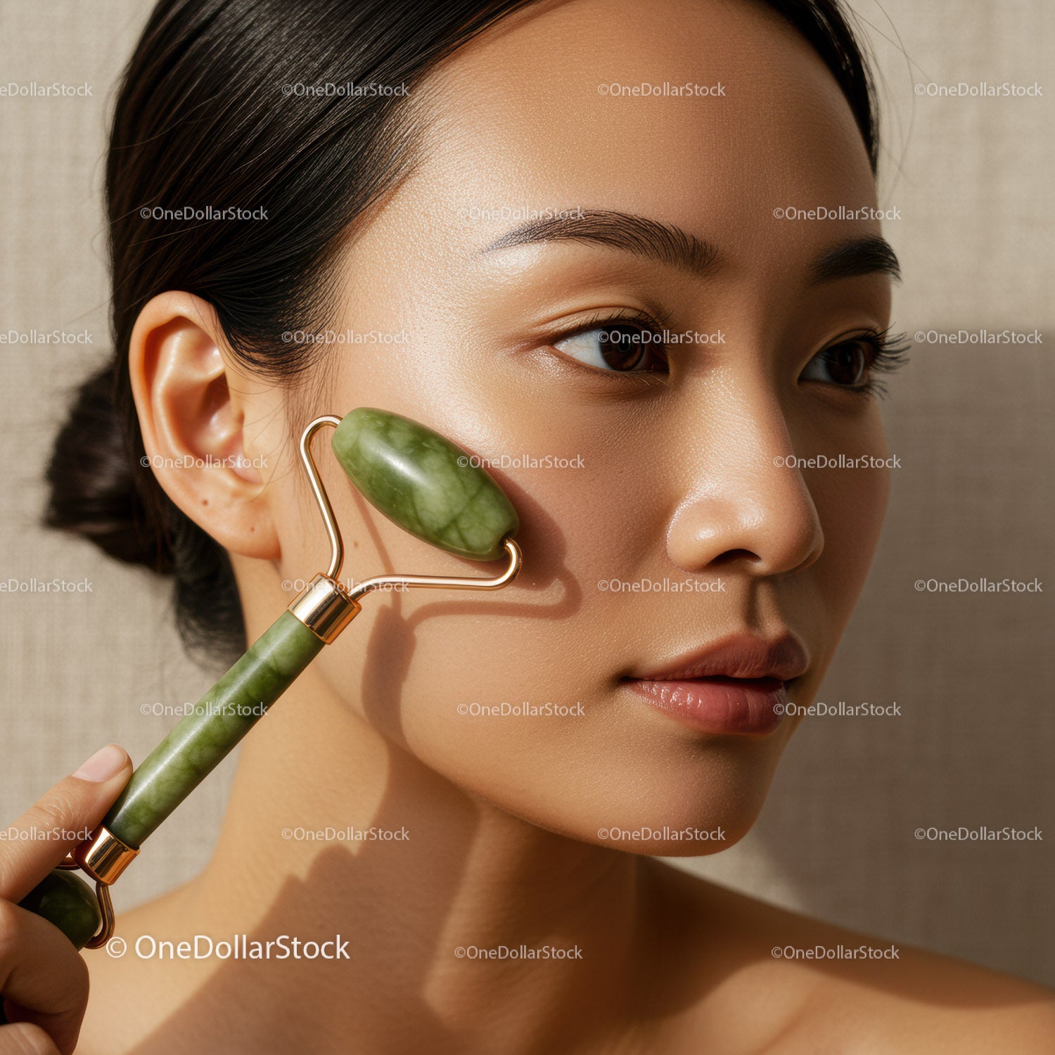 Asian Woman Using Jade Roller for Facial Skincare and Relaxation