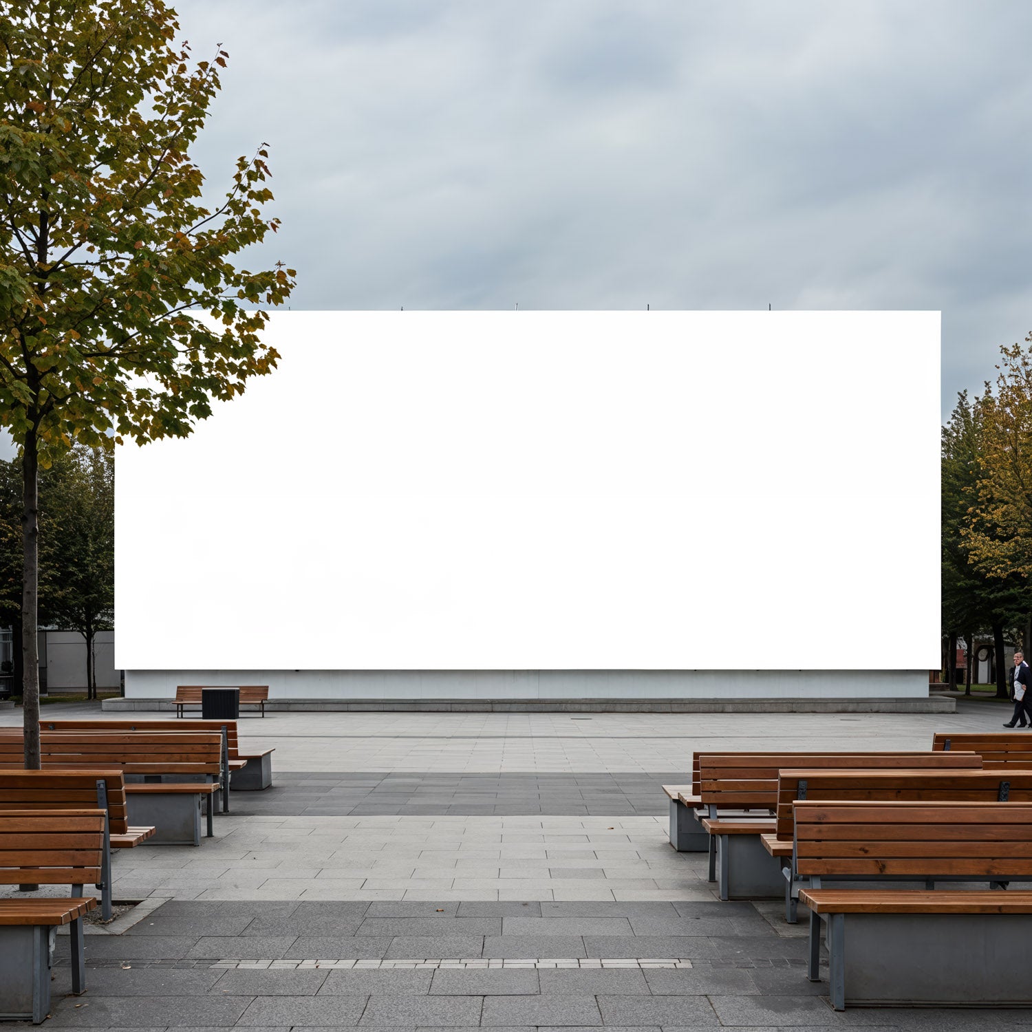 Outdoor cinema setup with empty wooden benches and blank screen