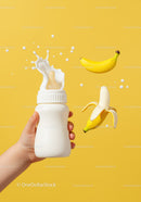 Baby hand holding bottle with milk splash and bananas