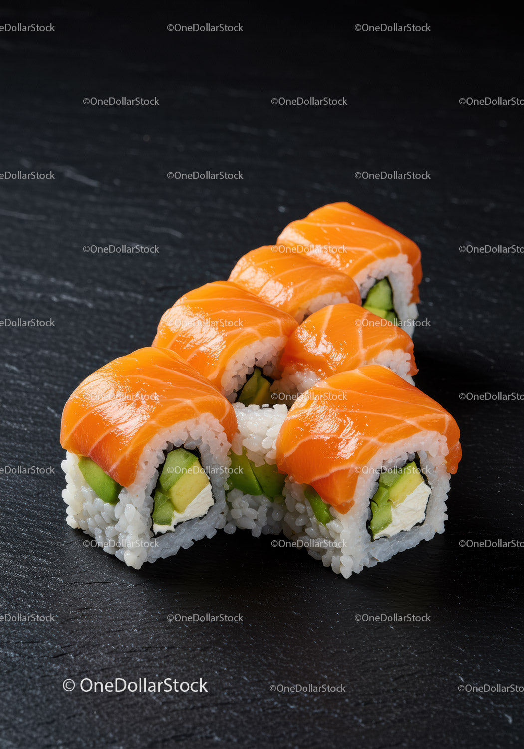 Rolki sushi z łososiem i awokado na ciemnej powierzchni łupkowej